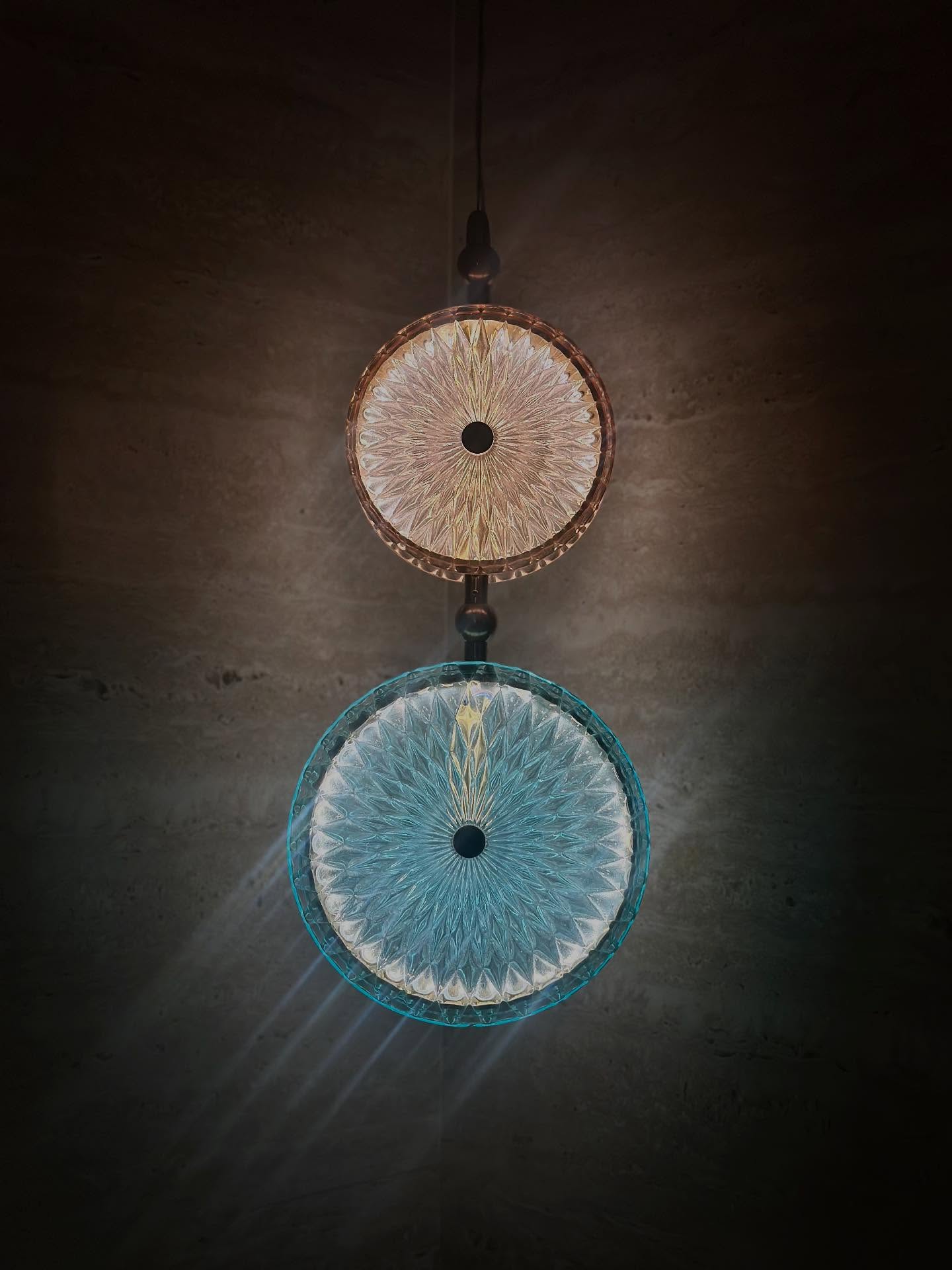 A circular woven pendant lamp suspended in a dark room.
