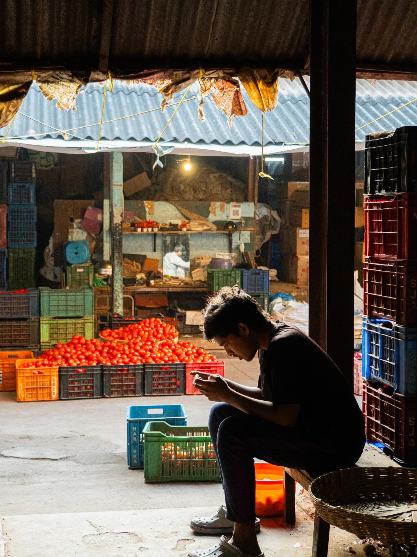 A small food stall beneath a corrugated roof, lit by a warm bulb.