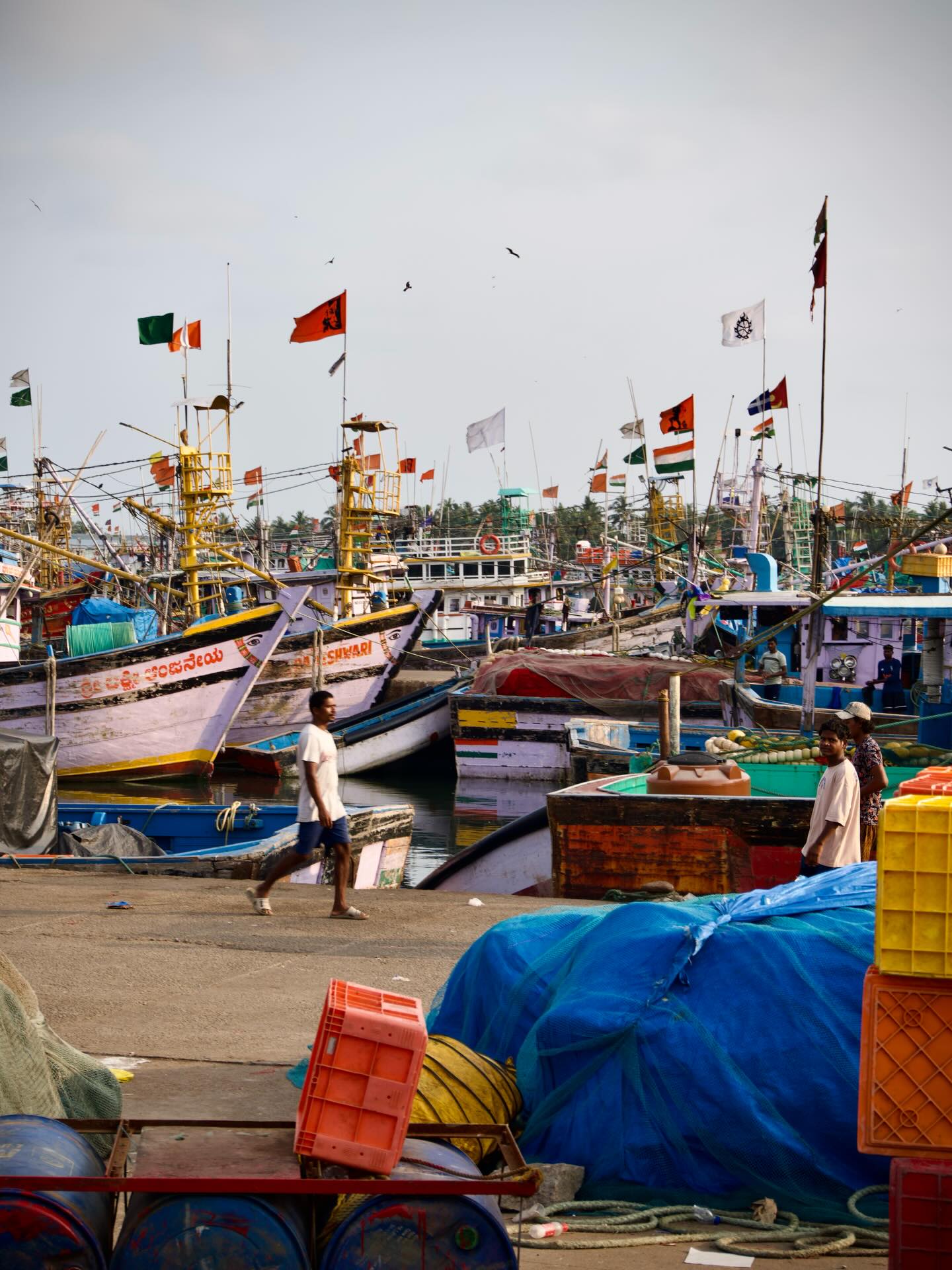 Colorful fishing boats and flags gathered beside a harbour.